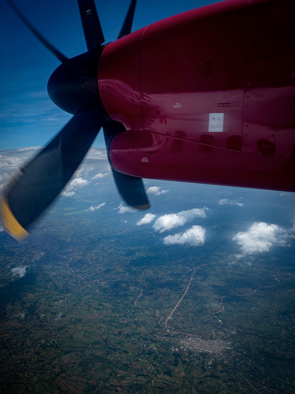 A red plane engine with a black and yellow turbofan.