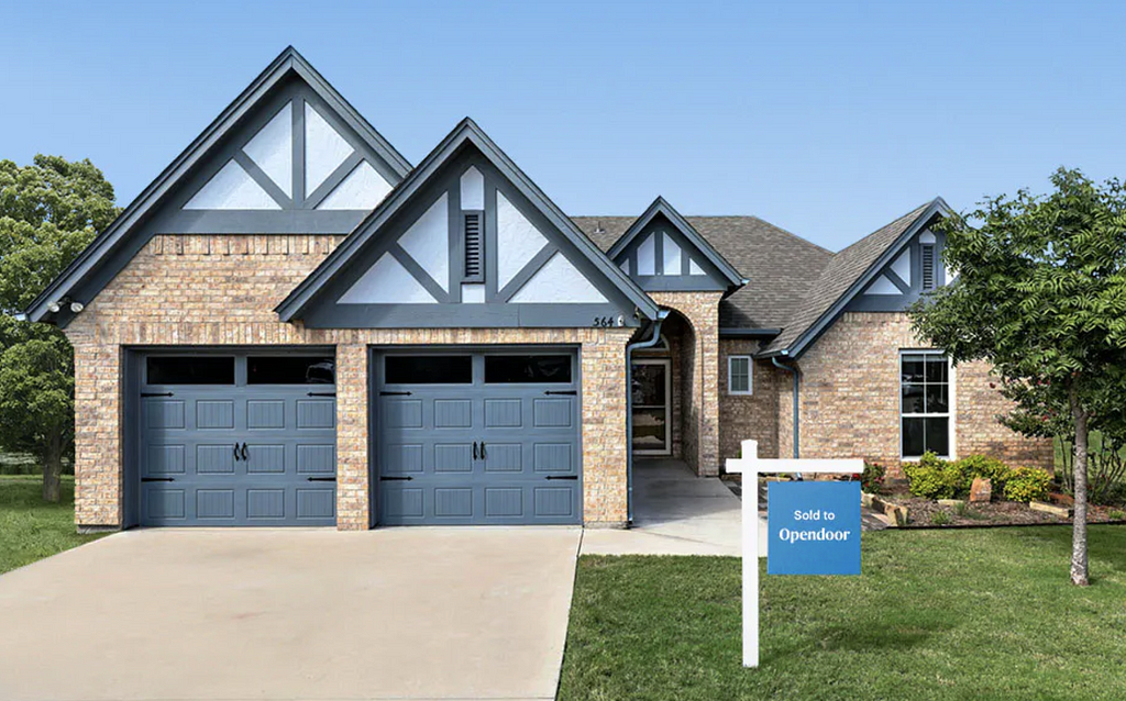 A home, viewed from the road, with a “sold to opendoor” sign in the yard.