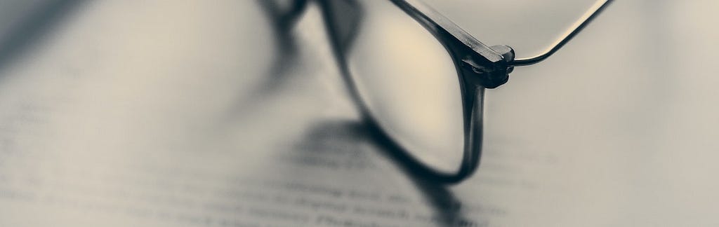 A pair of glasses sits on top of a law textbook.
