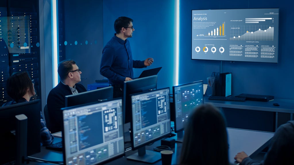 Students and lecturer during cybersecurity class sitting in front of computer screens on cyber range training platform