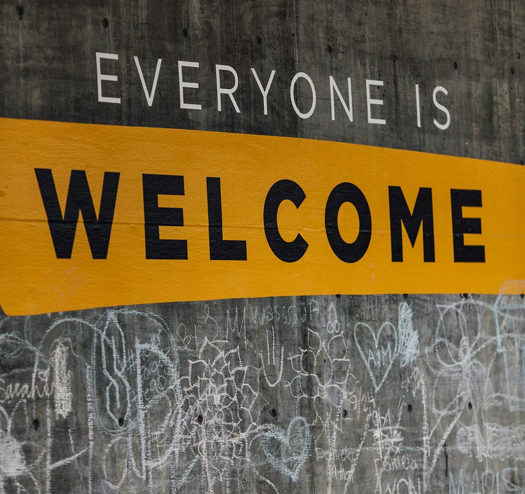 Large sign on wall saying “everyone is welcome”.
