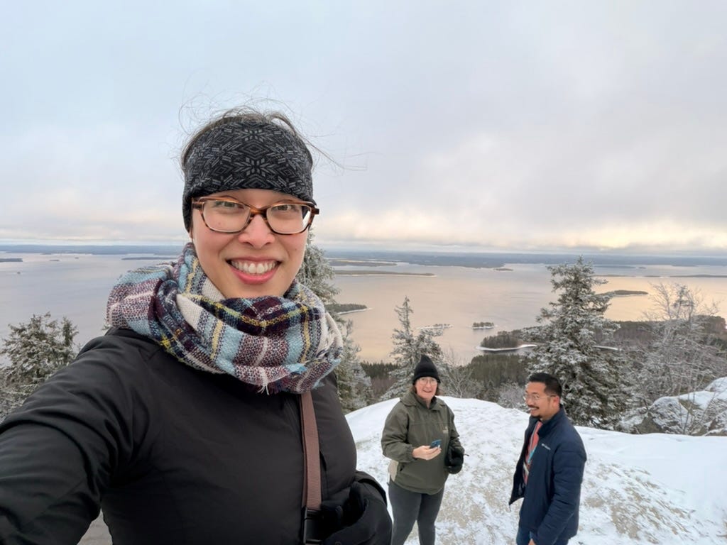 Amy smiling in the camera, with Francisco and Michelle chatting below, and the pristine lake in the background.