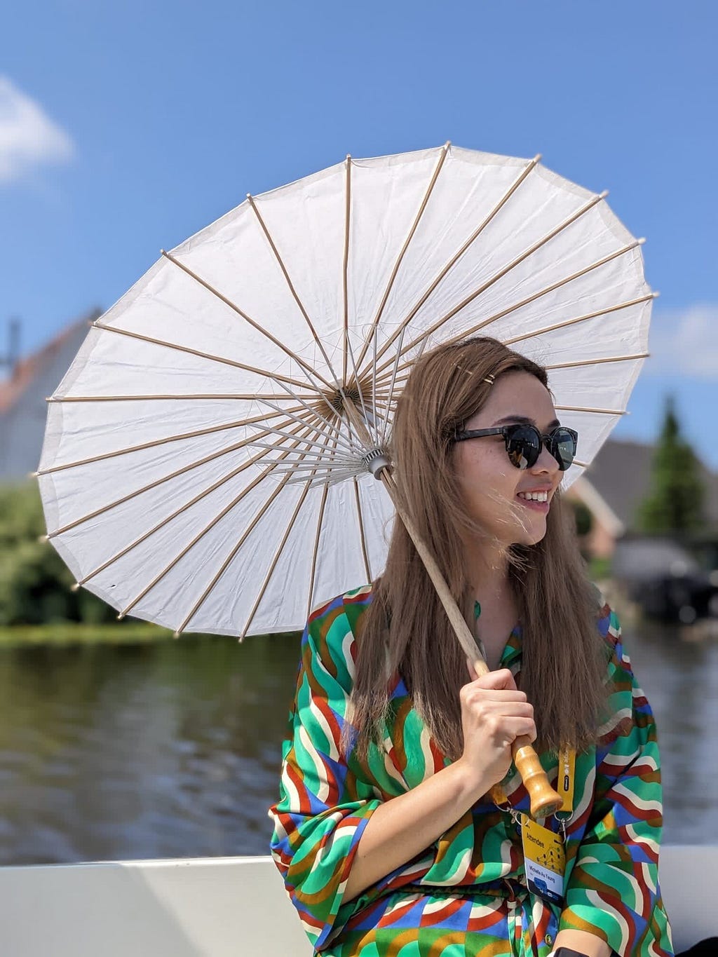 Michelle with a paper umbrella sitting on a canal cruise at a Google partner event