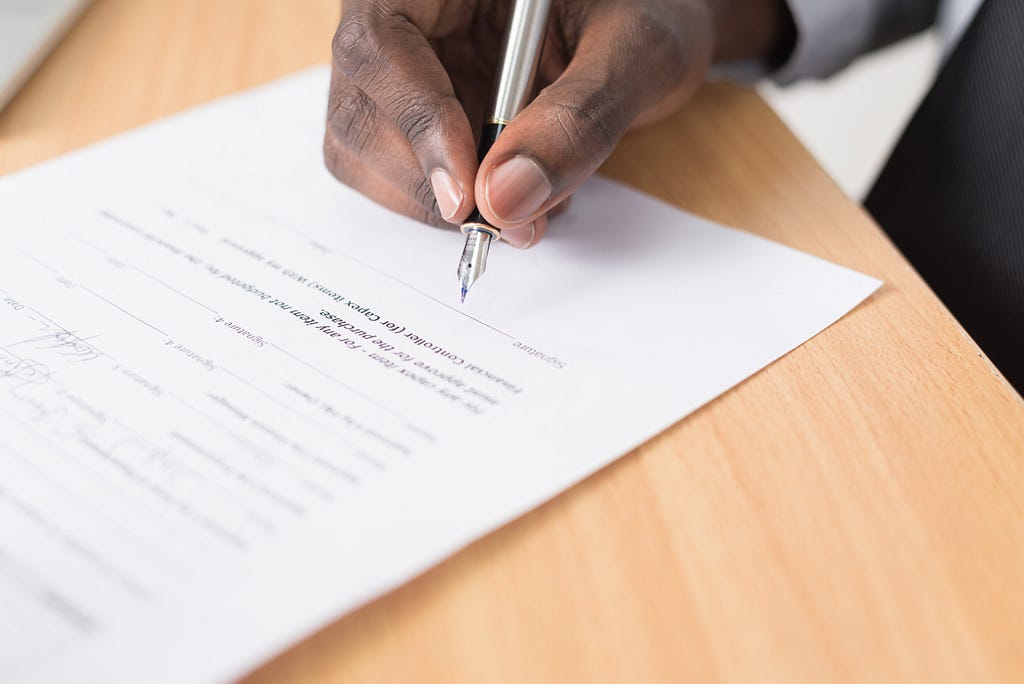 Person signing a paper contract