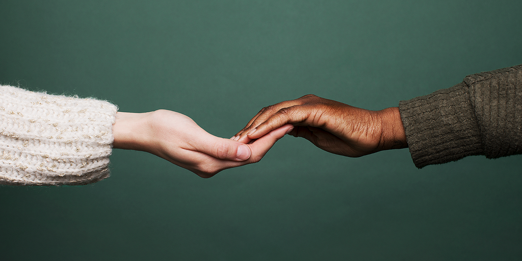 2 people touching hands in a show of community support