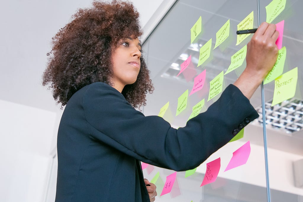 successful woman using post it notes for productivity