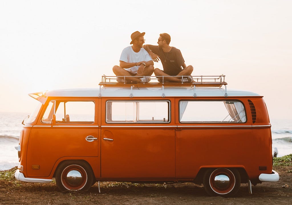 Backpackers chilling on the roof of their camper van