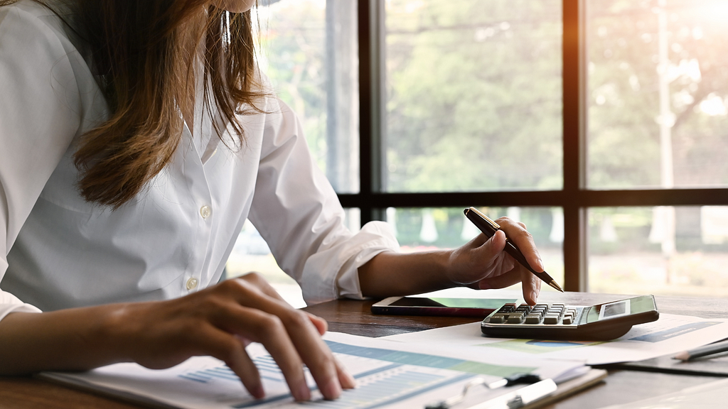 Woman calculating finances at a table.