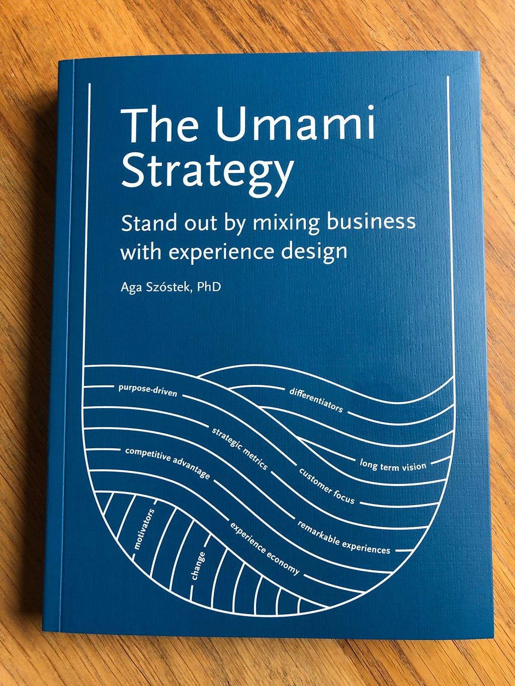 The book “The Umami Strategy: Stand out by mixing business with experience design” laying on a table