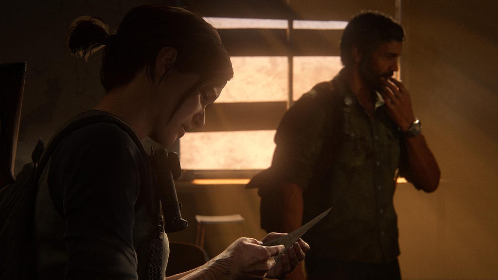 Ellie reading Adam’s letter, Joel to her right holding a hand to his face.