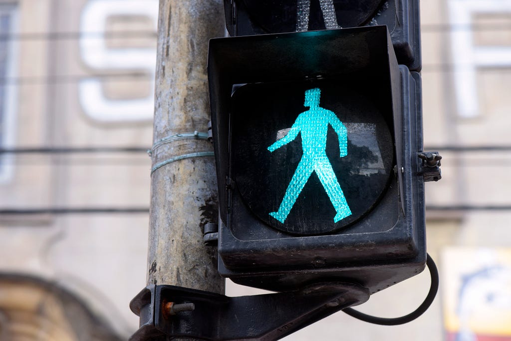 Green light walking sign on a street pole.