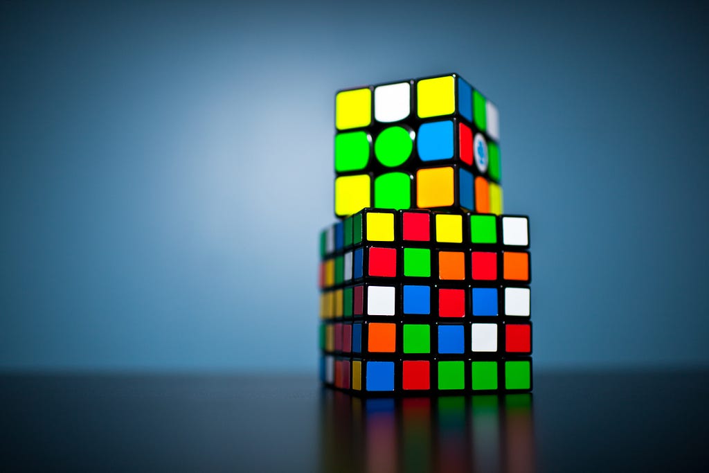 Two unsolved Rubik’s cubes stack on top of each other.