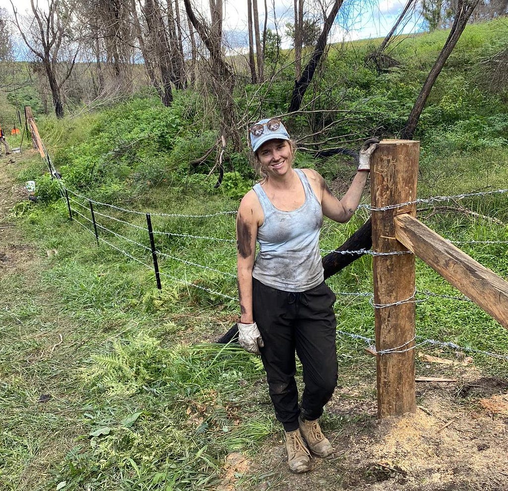 The author standing next to a completed barbed wire fence.