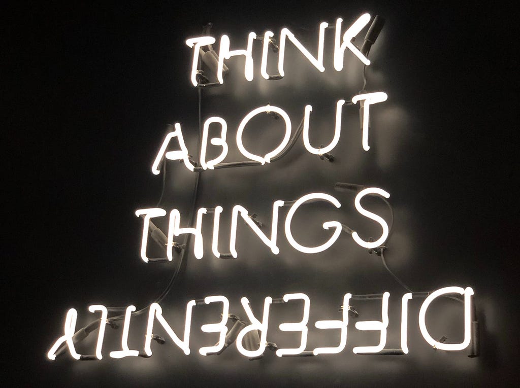 Neon sign that says “Think About Things Differently”