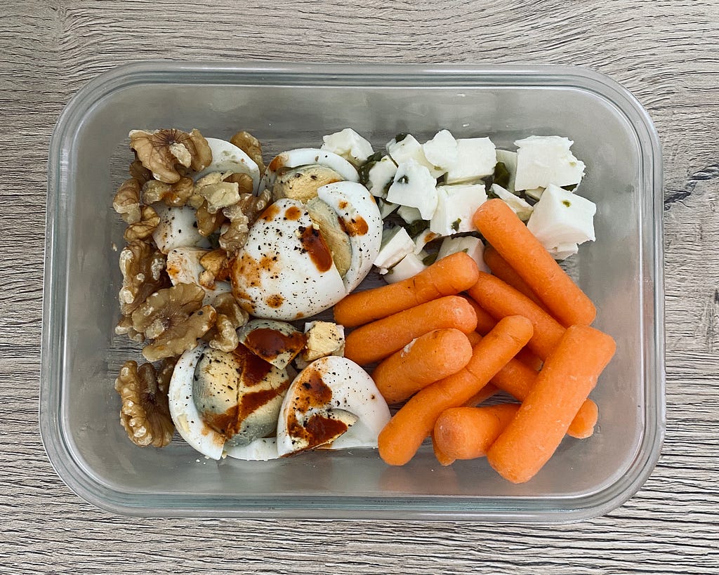 Home-made meal of boiled eggs, walnuts, carrots and fresh cheese