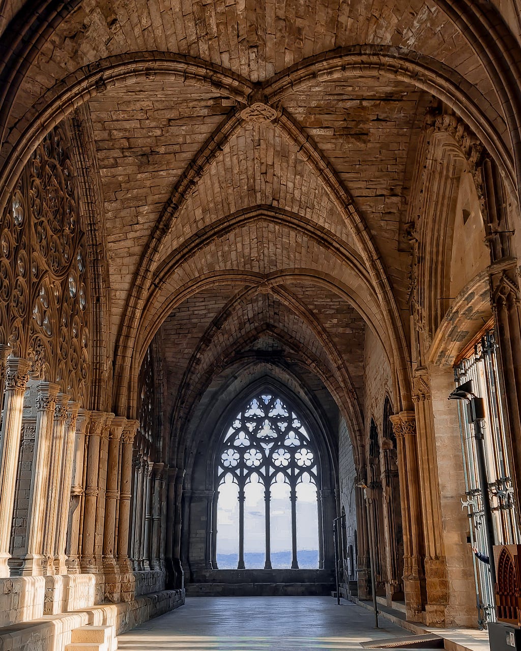 View of one of the windows of the Seu Vella cloister, with several columns and arches, arabesques, and decorations, all in stone, with a play of lights and shadows coming from the sunset.