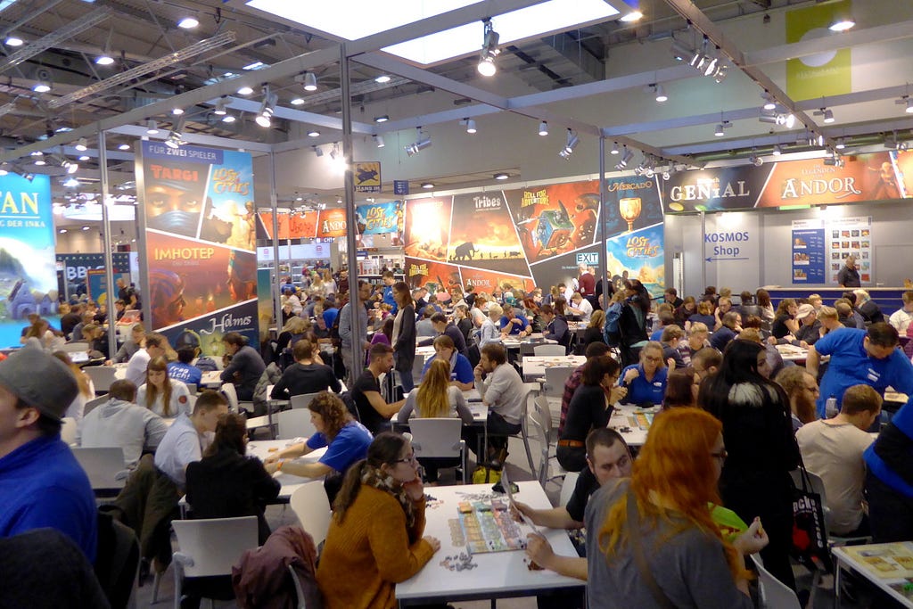 Visitors test playing board games at the stand of Kosmos (photo from 2018)