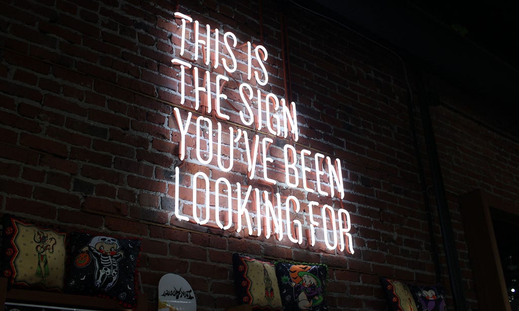 A neon sign that says This is the sign you’ve been looking for.