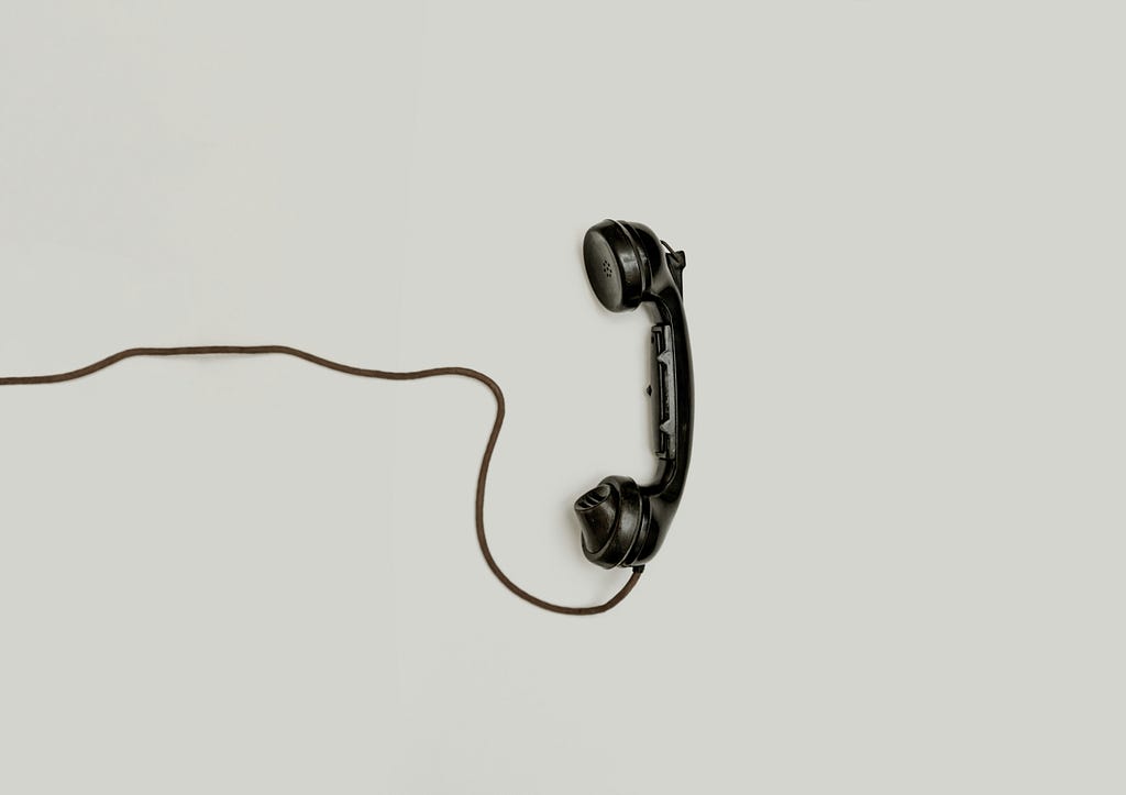 Old style black telephone receiver and cord