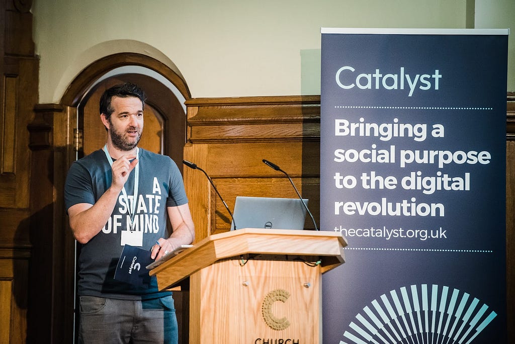 An image showing CAST Director Dan Sutch standing at a podium at the Catalyst launch event