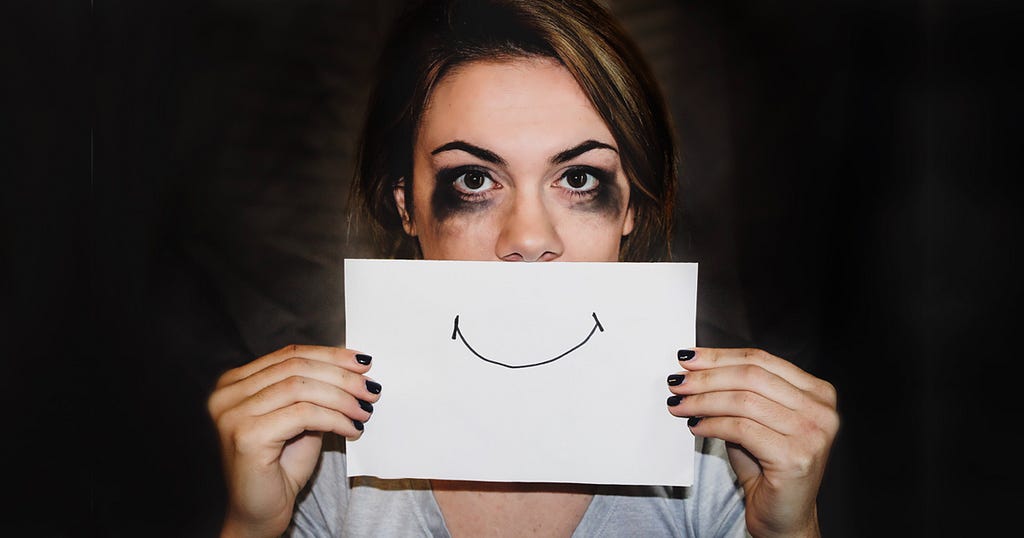 A stressed woman showing a paper with a smiley