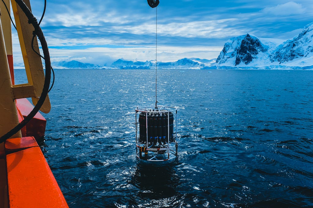 The deployment of an ocean instrument in an Antarctic fjord.