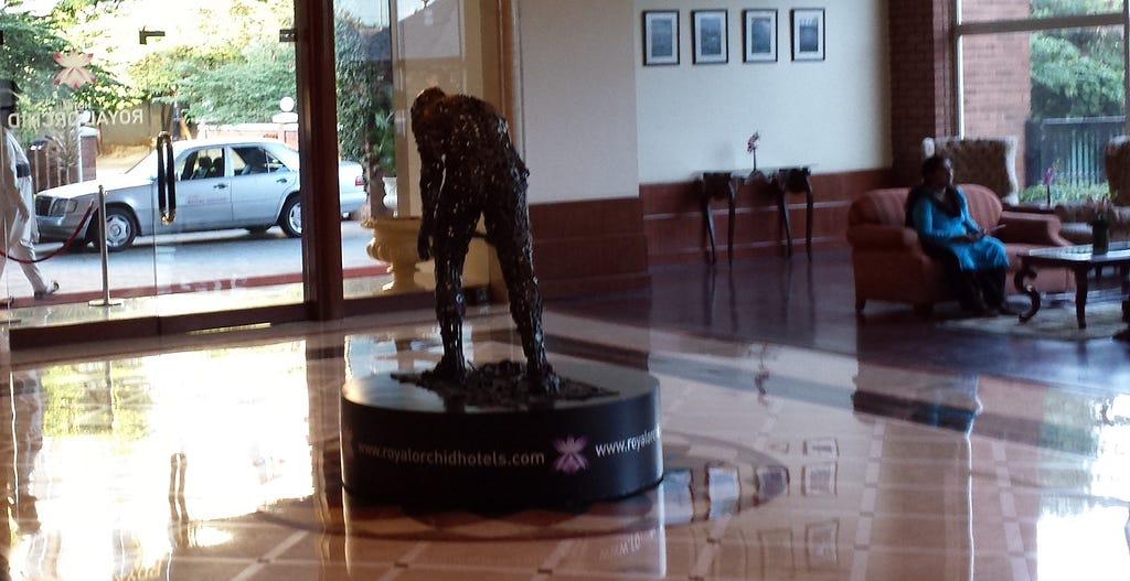 Royal Orchid lobby statue and guest sitting in sofa