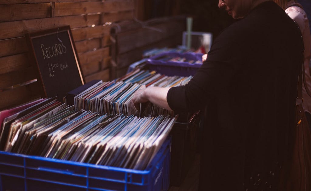 a person looking through records at a record store