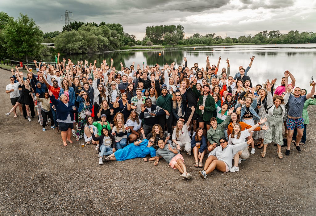 A whole company wide photo from our summer conference standing in front of a lake