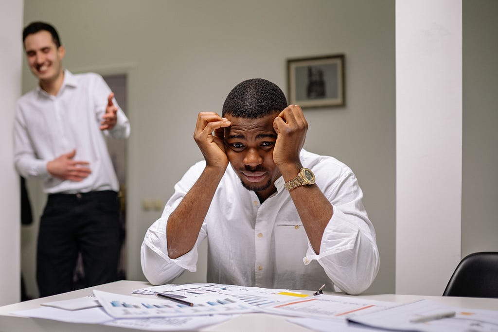 Man sitting at a desk, frustrated.