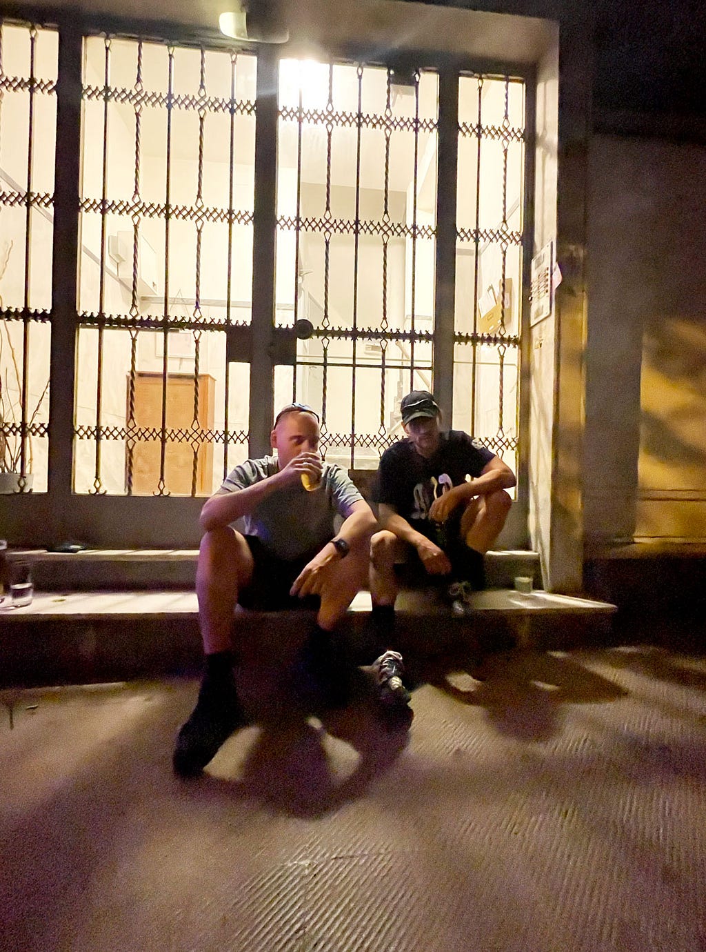 The two founders of NMRDOTCC sitting in front of a building in Athens, George on the left drinking beer, Spiros on the right
