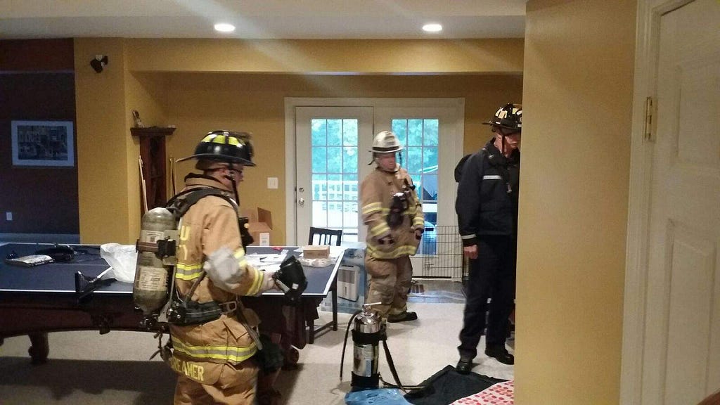 Picture of firemen standing in my basement staring at the scene of the incident.