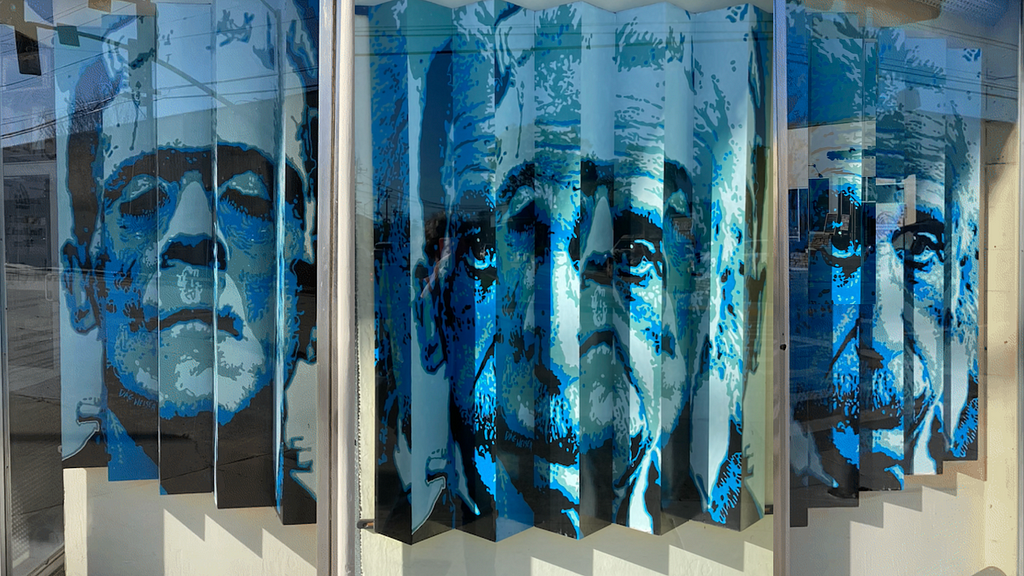 Storefront window with the lenticular poster of the Einstein becoming Frankenstein based on the angle of view.
