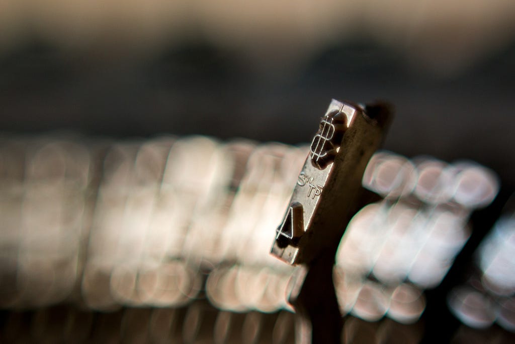 Closeup of typewriter key with dollar sign and the number 4