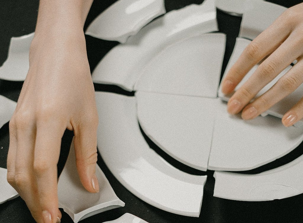 Person putting back together a broken plate.