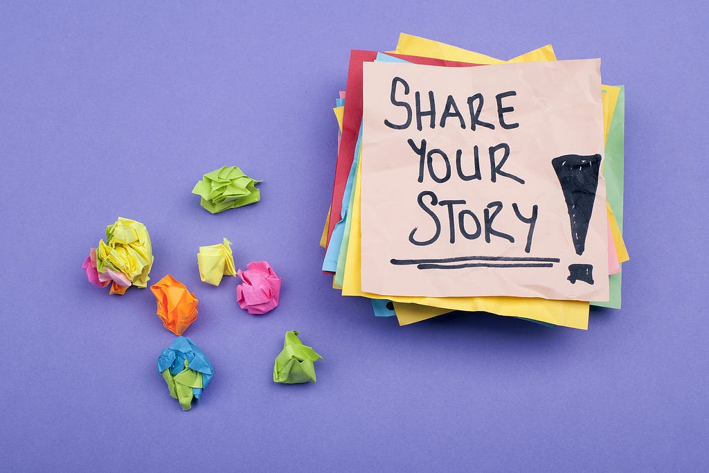Post-It note with the words Share Your Story on it