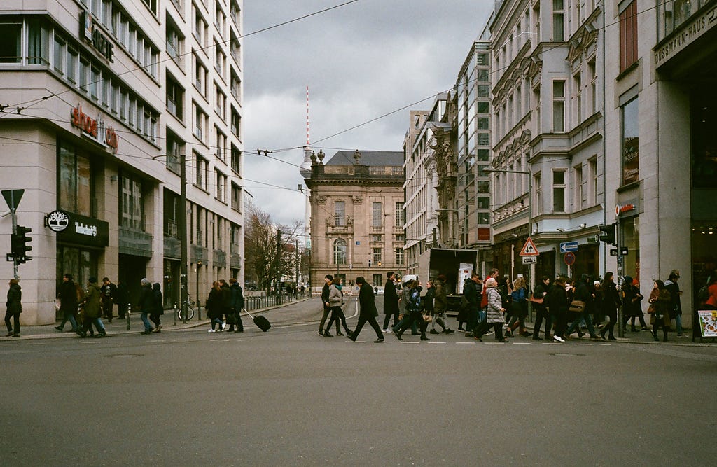 Crowd of people strolling on crosswalk in city district