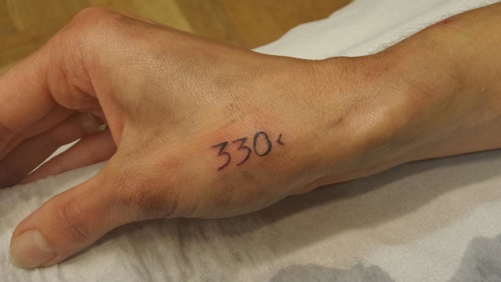 Tattoo of “330<” on someone’s right writs.