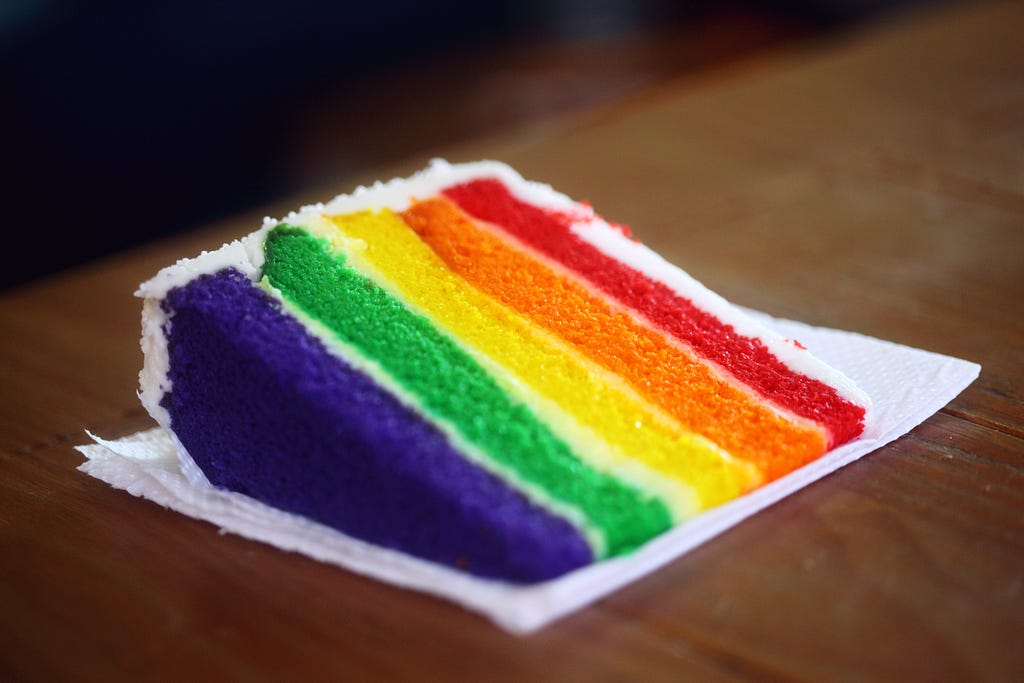 Cake slices showing layers in the colors of the rainbow