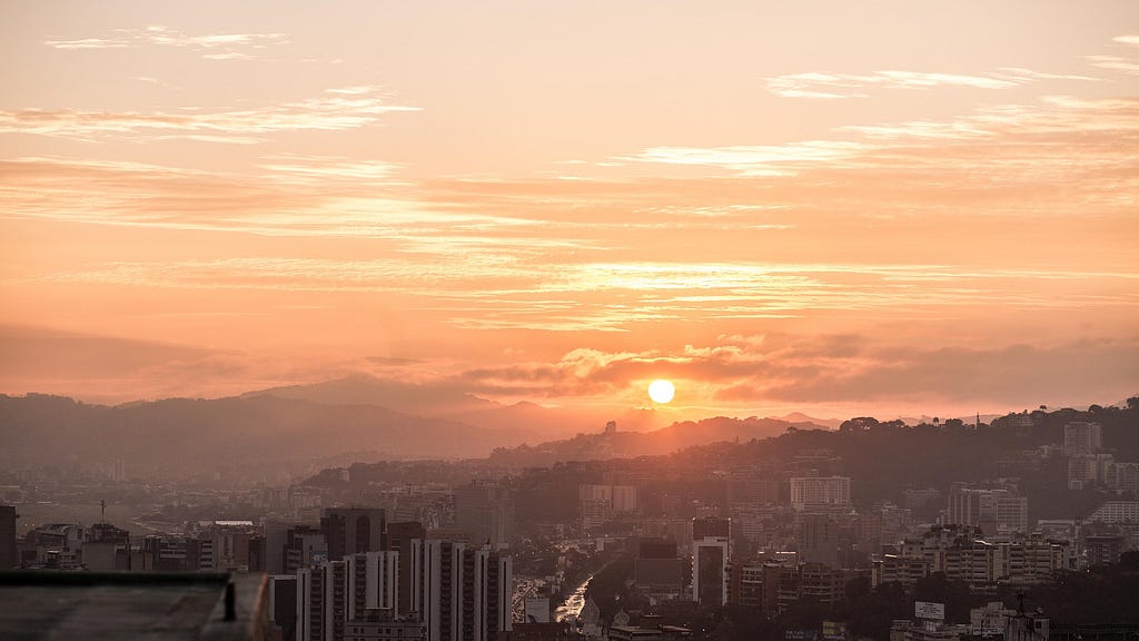 Sunrise over the city of Caracas with mountains in the background.