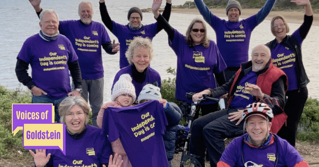 A group of Voices of Goldstein members cheering at the camera, all wearing purple t-shirts that read ‘Our Independents day is coming’