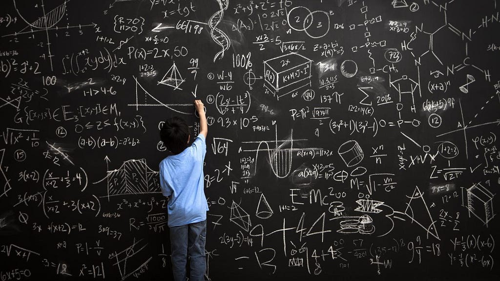 kid writing formulas on black board