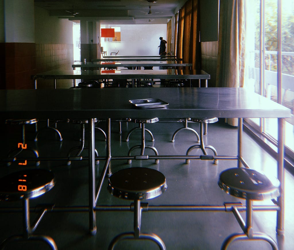 A mess table in hostel with seats that can flip inside the table to save space.