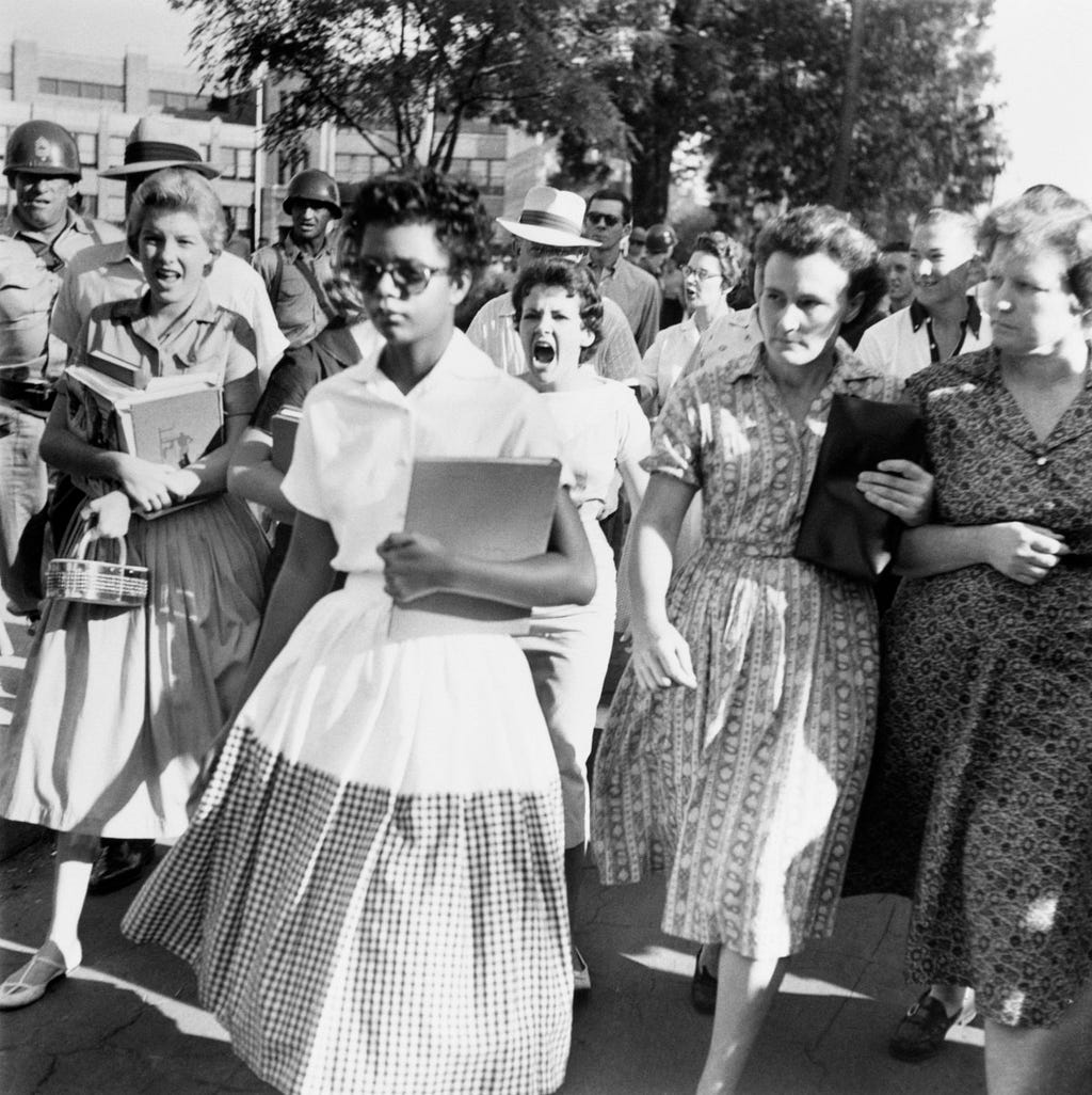 Elizabeth Eckford walks into Little Rock High in 1957 while white students taunt her