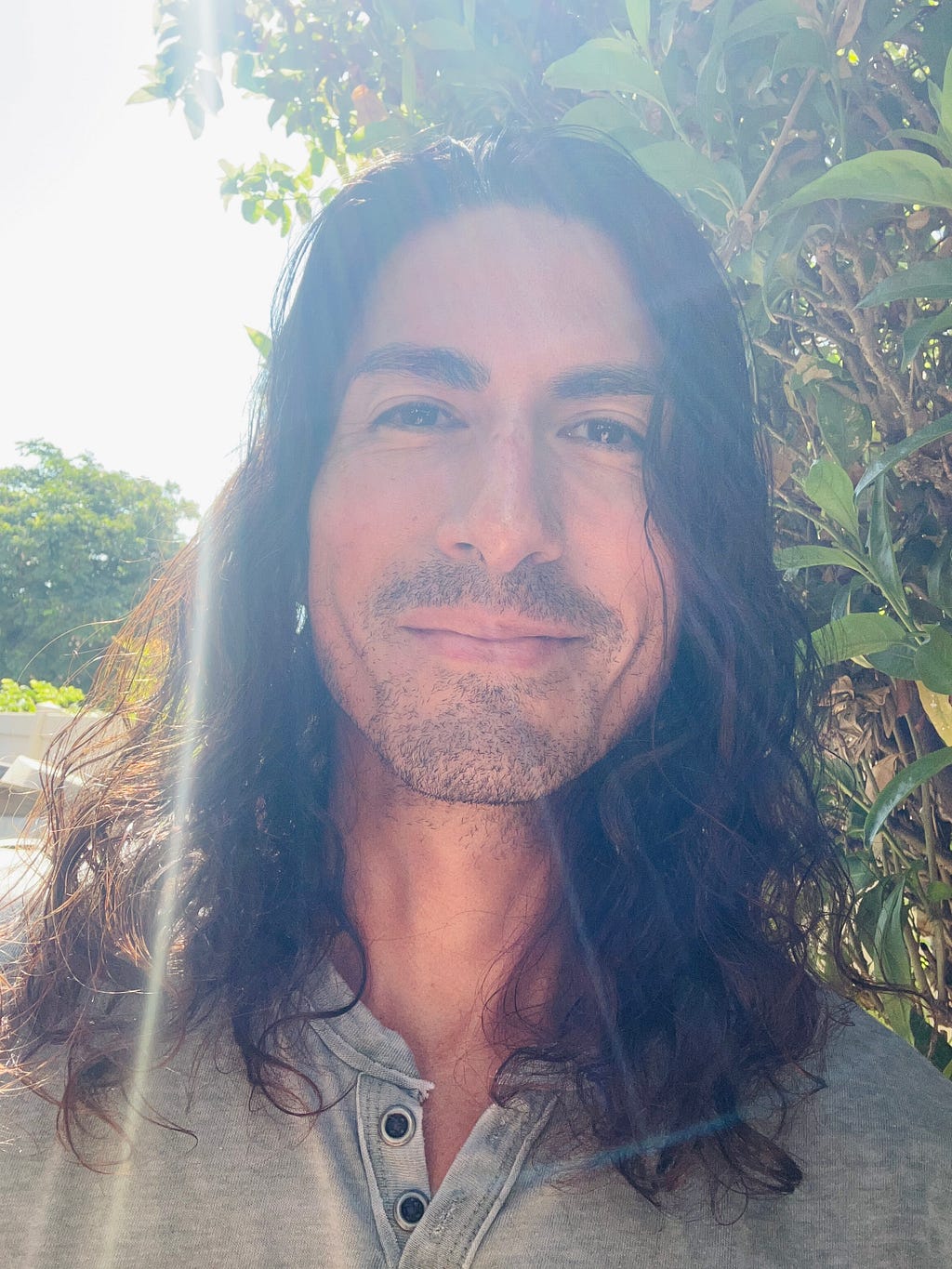 long-haired man with sunlight shinning down on him