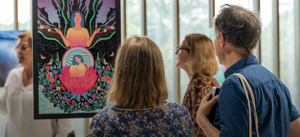 A woman and a man admiring a painting at an exhibition at Daftarkhwan | Downtown.