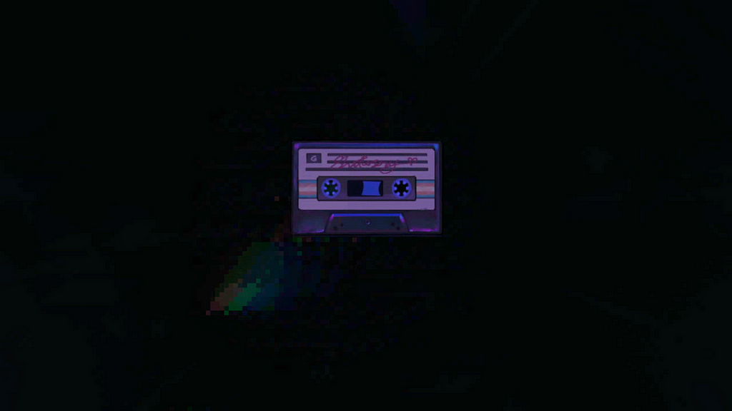 A screenshot of the map Shattersong. Madeline has collected a cassette tape, made of an iridescent material and labeled “Shattersong.” There is a pattern of blue, pink, and white stripes across the length of the tape.