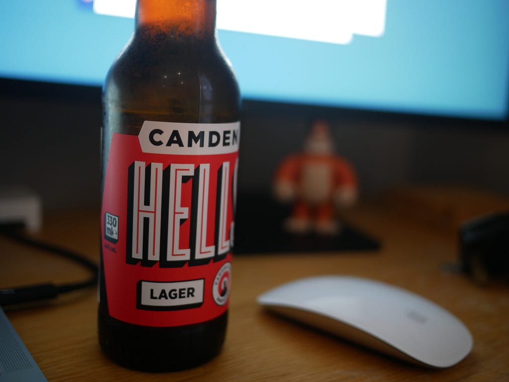 A bottle of Camden Hells lager on a desk