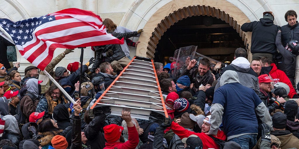 Rioters clash with police using big ladder trying to enter Capitol building through the front doors.