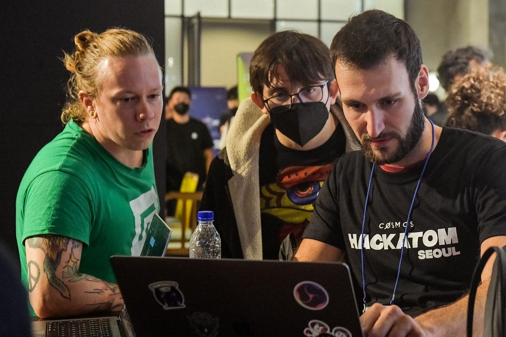 A photograph taken at the Hackatom event in Seoul 2022, showing Gjermund observing the Interchain Foundation’s IBC Developer Relations Engineer Thomas Dekeyser coding.